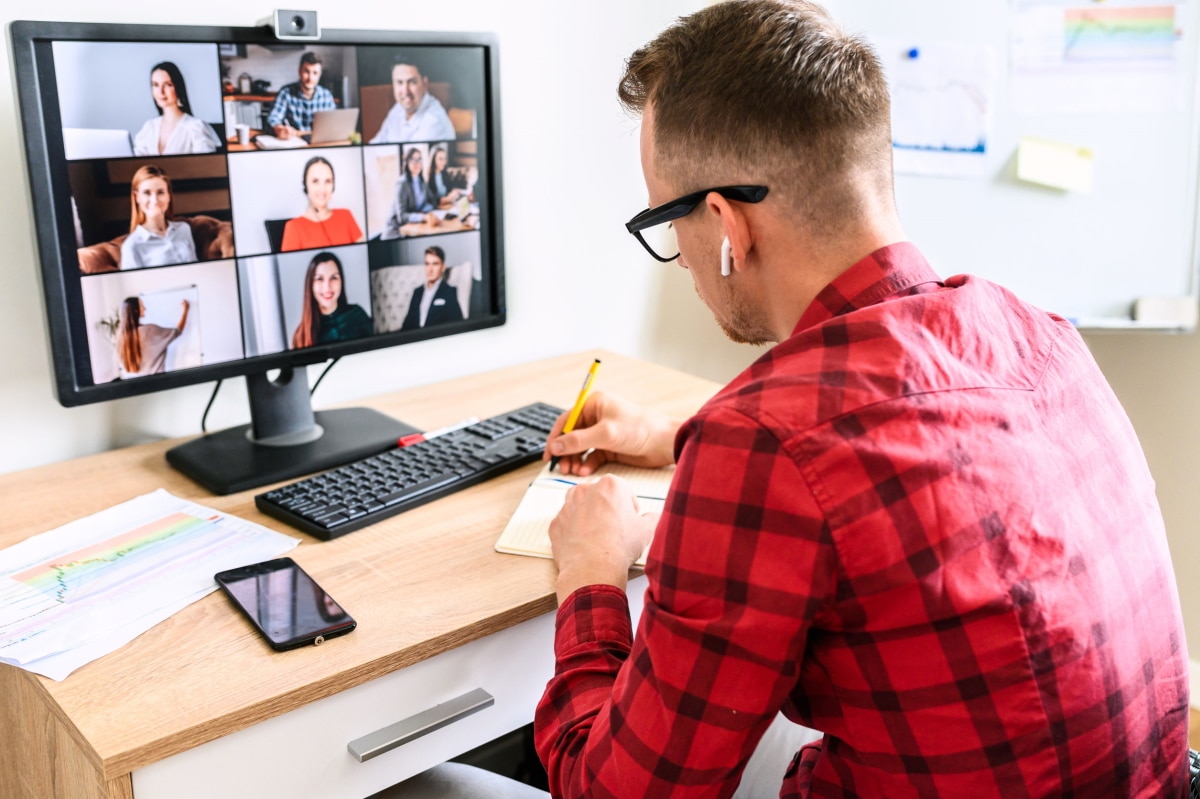 Mann beim Online-Meeting mit Kollegen